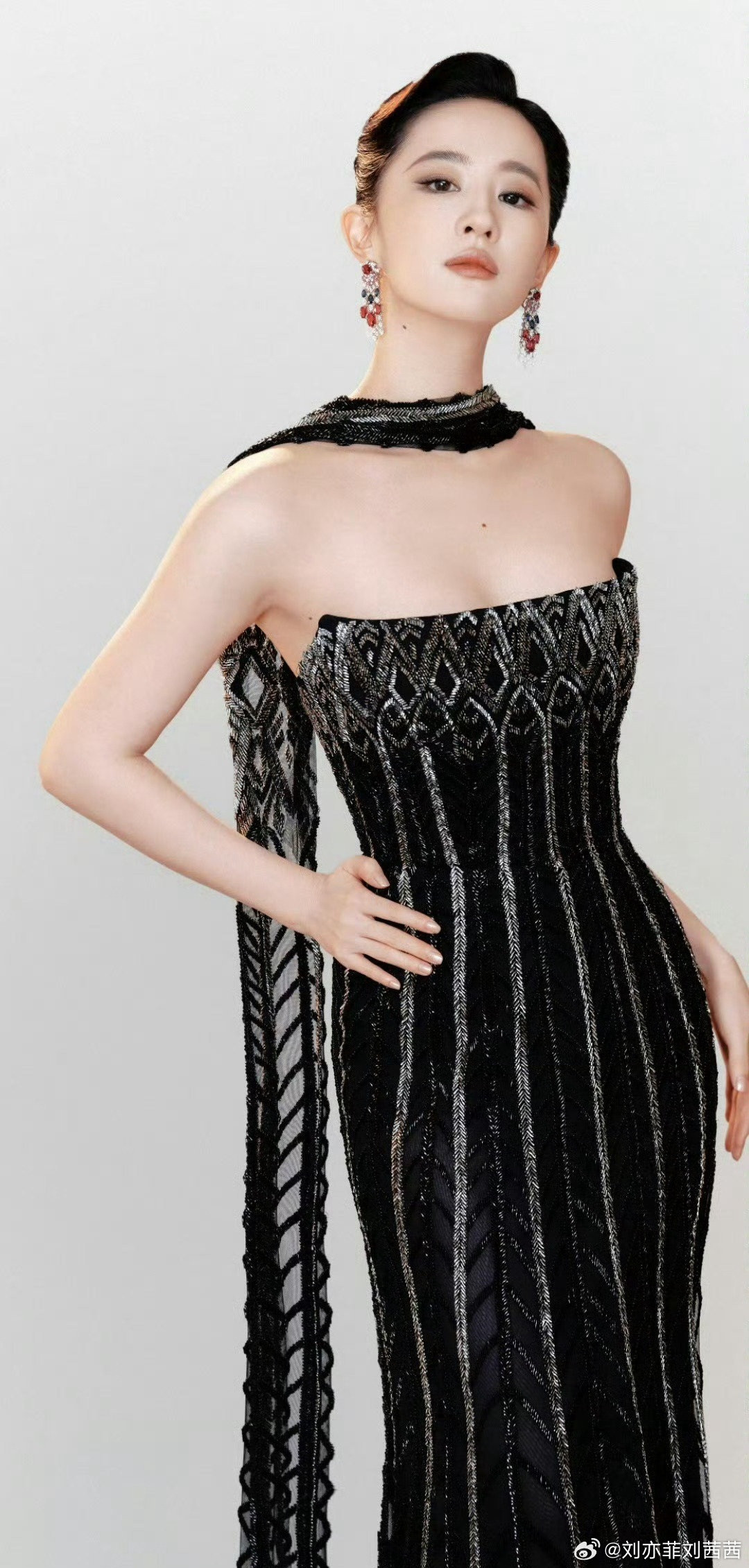 刘亦菲身着黑色抹胸鱼尾高定礼裙，裙身银灰色流线型亮纹从抹胸处一路延伸至曳地裙摆，