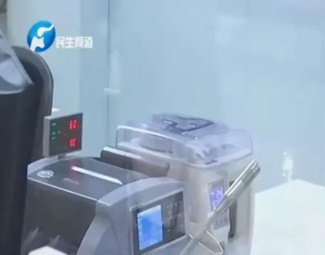 河南郑州，一女子担心太多现金放家里不安全，于是提着一扎一扎的钱来到银行，准备将4