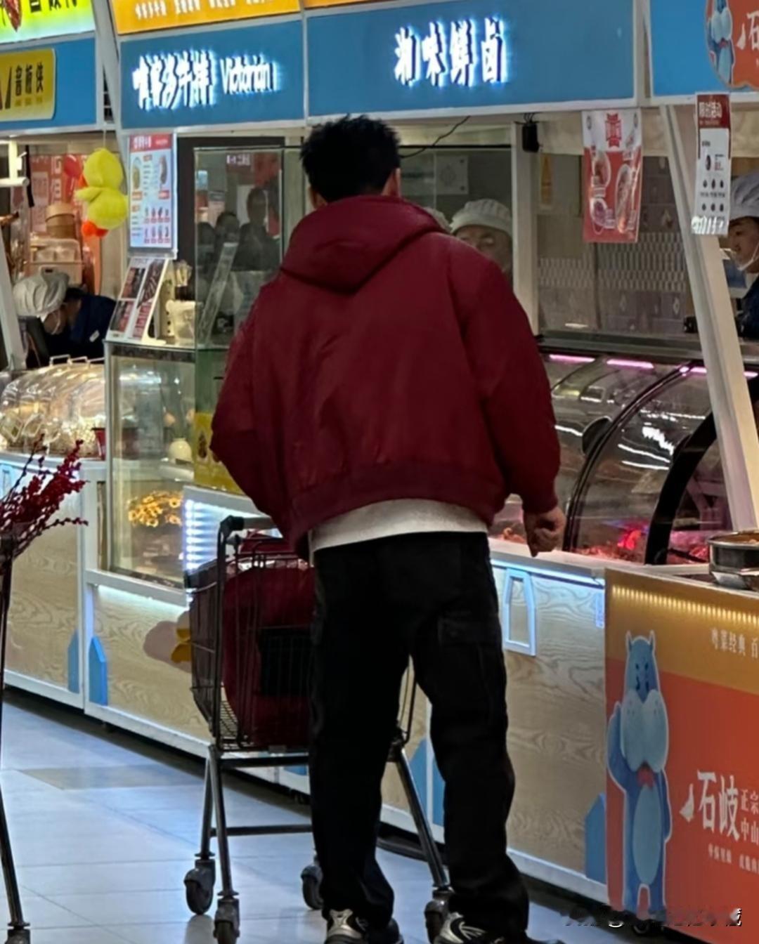 李晨现身长沙超市购物，被粉丝偶遇拍照分享。照片中，李晨推着购物车，驻足熟食购物区