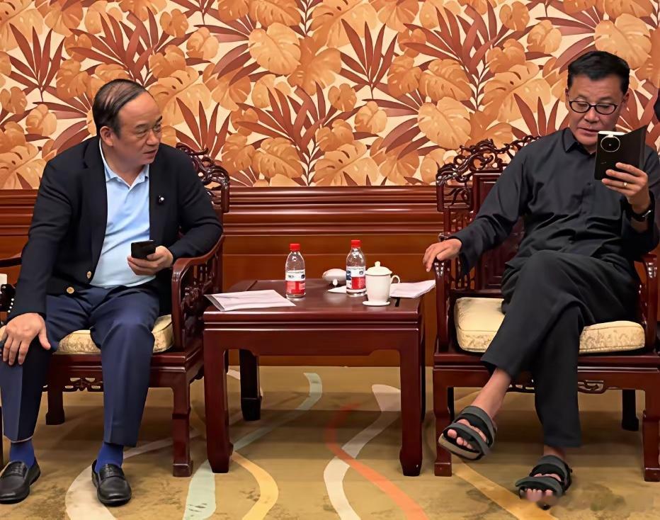 李国庆与东星集团创始人兰世立在一起交谈时的一幕，李国庆脚上穿着一双拖鞋。​​​