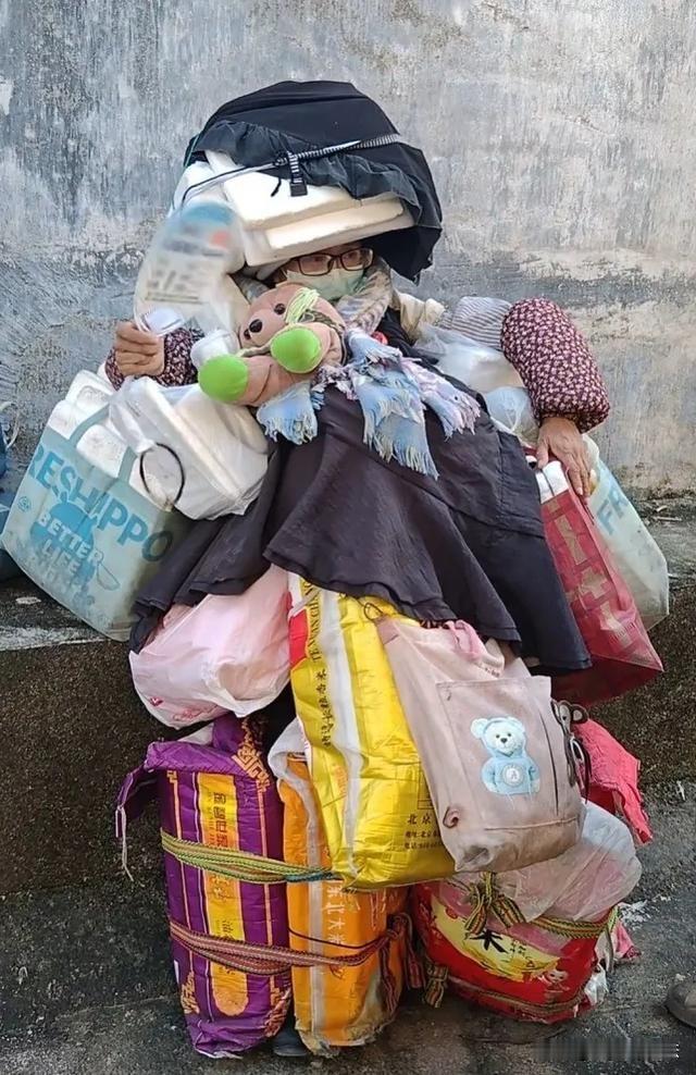 江西赣州，一女子全身挂满袋子，袋子里装着泡沫板，四肢和头顶上都绑着袋子等行李物品