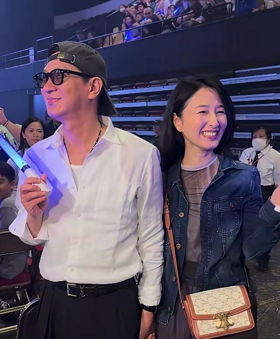 张家辉、关咏荷近照，夫妻俩一起看演唱会的画面，好浪漫的样子。关咏荷被张家辉牵