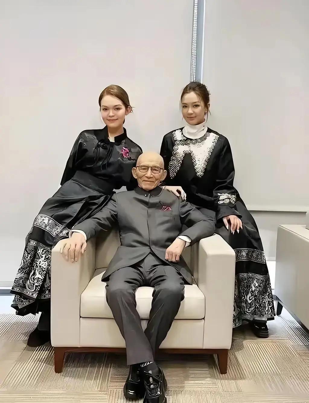 游本昌和两个孙女合照，他已经91岁了，一身黑色西装，精气神十分不错，两个孙女出落