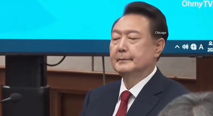 尹锡悦终于坐在被告席上了！尽管他西装领带，尽力维持自己的体面，但桌上的“被告人