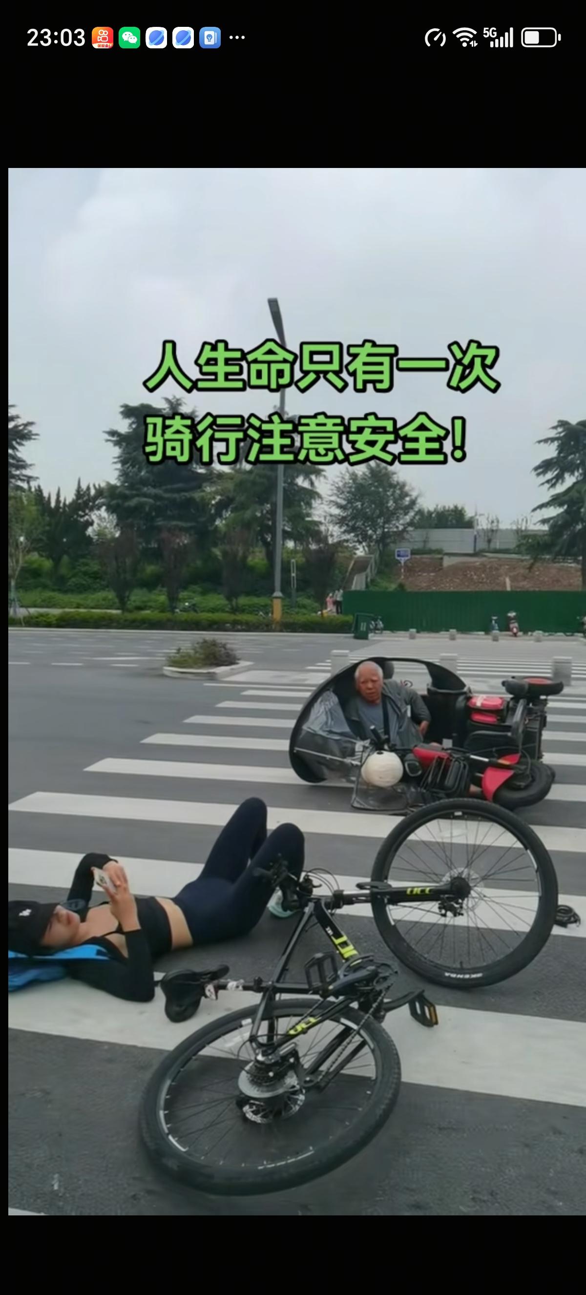 女骑行者骑着山地自行车在斑马线上和开三轮电动车的大爷相撞了，俩人都翻车了。女骑行
