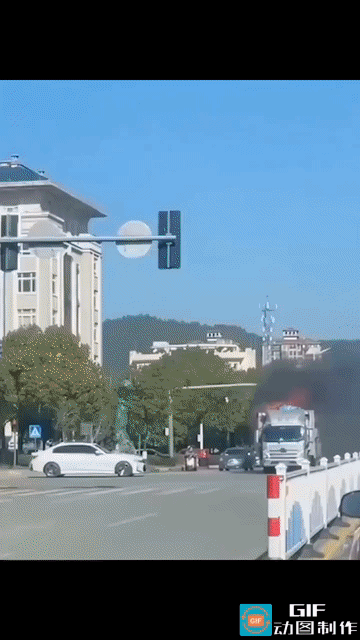 网投震惊了:车来车往的马路上，一辆快速行驶的大货车，后面的货不知怎么的着火了。整
