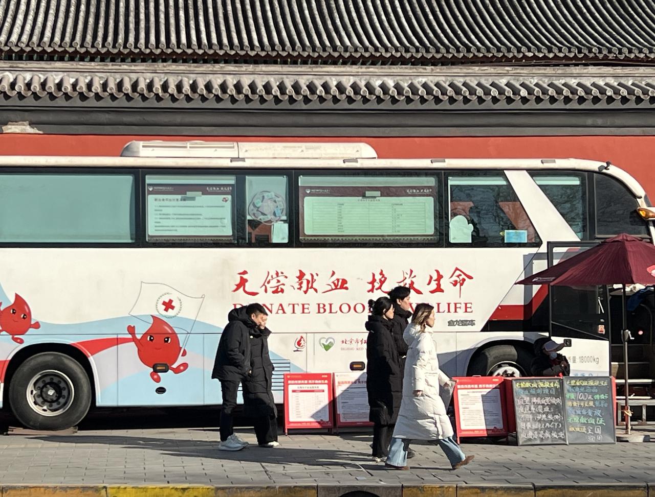 路边无偿献血活动车的喇叭一声接一声，路过的人们看都不看一眼……