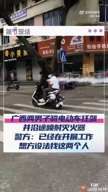 广西来宾一处街头，两名戴着口罩的男子骑电动车一路狂飙，坐在后座的男子更是手拿灭火
