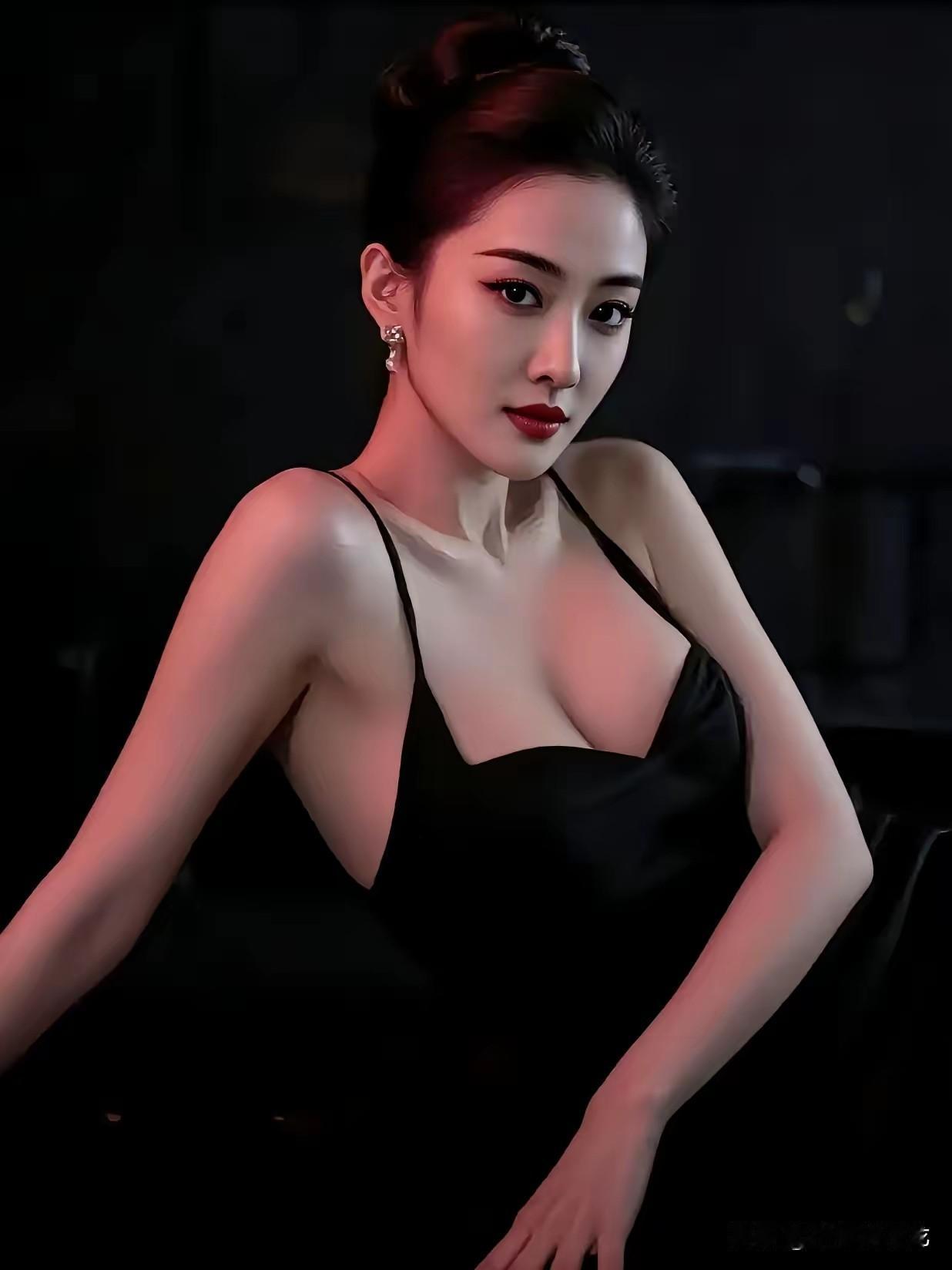 她眼里有光暗调空间里一束红调侧光落在肩头，黑色吊带裙的丝滑面料泛着柔和的哑