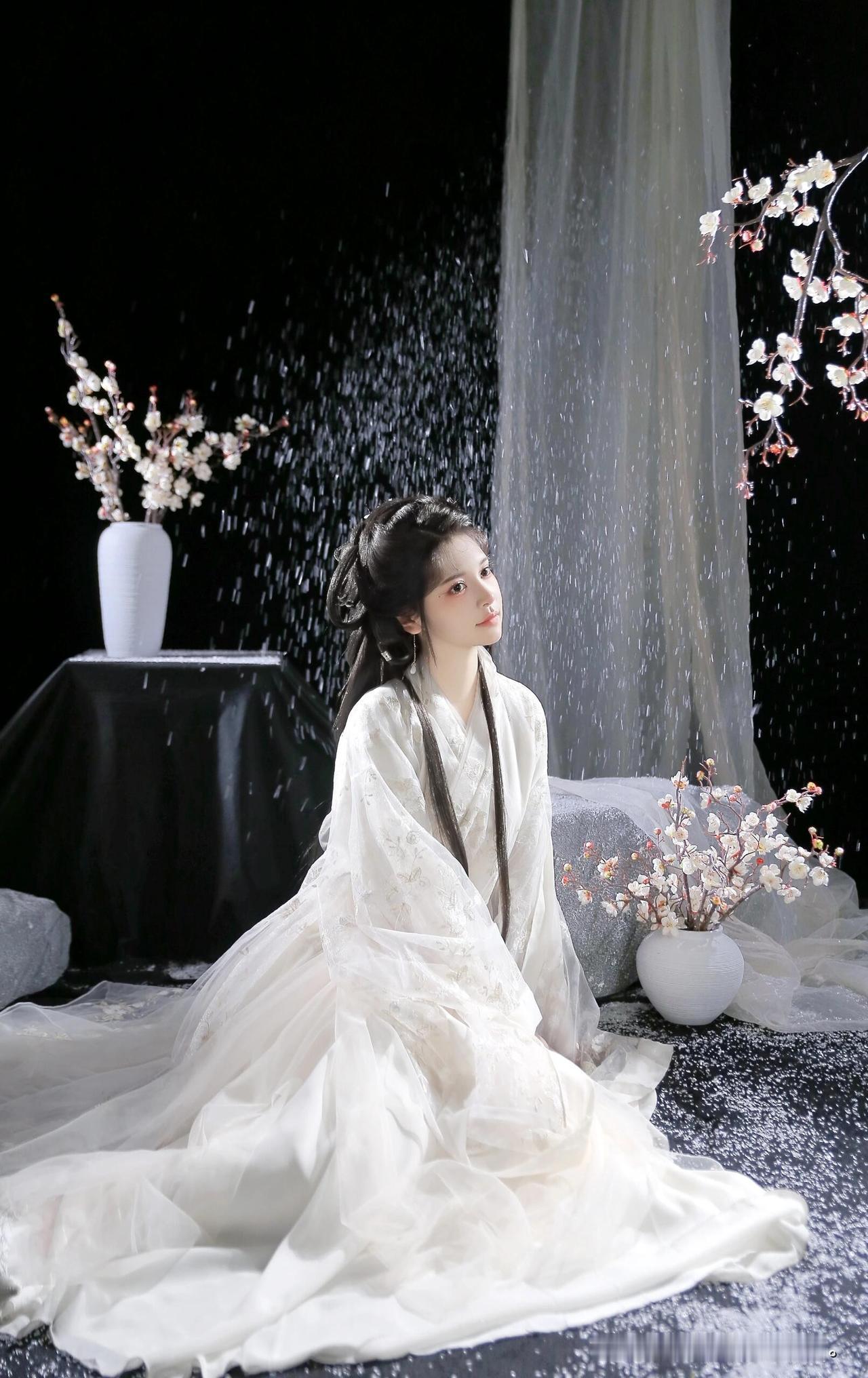 雪落无声，白衣少女静坐花间，宛如画中仙子。这一刻的静谧美好，值得珍藏心底~