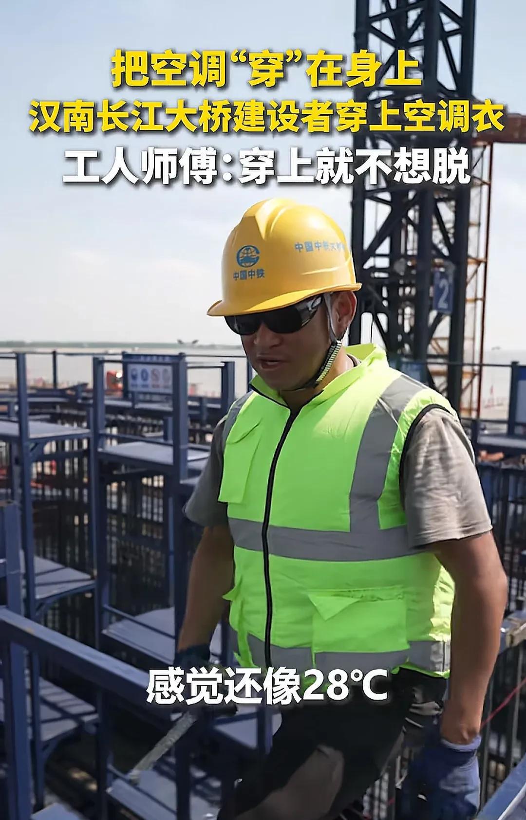 湖北武汉，汉南长江大桥的建筑工人在干活时没有以前那么热，穿上了空调服。这个空调
