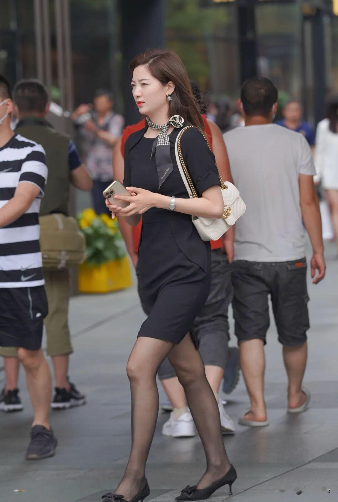 这姑娘穿得真时髦，手机不离手。