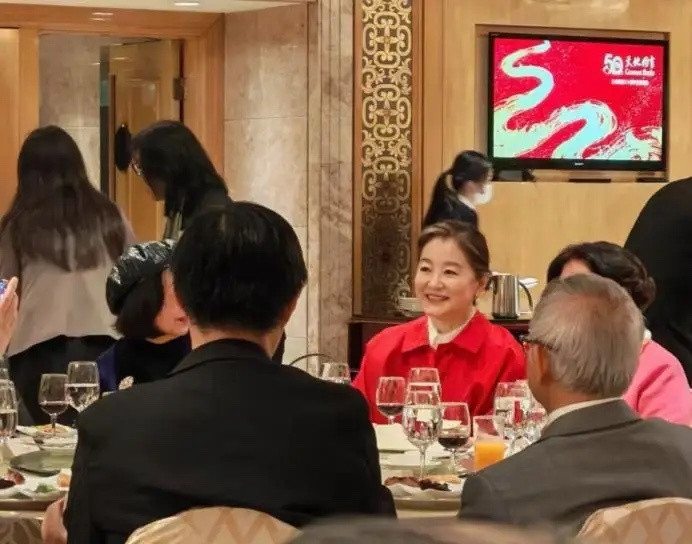 林青霞现身酒店参加朋友的喜酒，她染了棕发，面色红润，她穿着大红色上衣，挽着发髻，