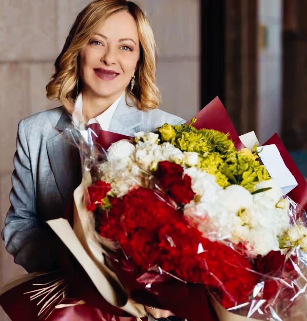 梅洛尼手捧鲜花，看起来是不是更加年轻漂亮了？梅洛尼微笑的表情看起来是不是非常自