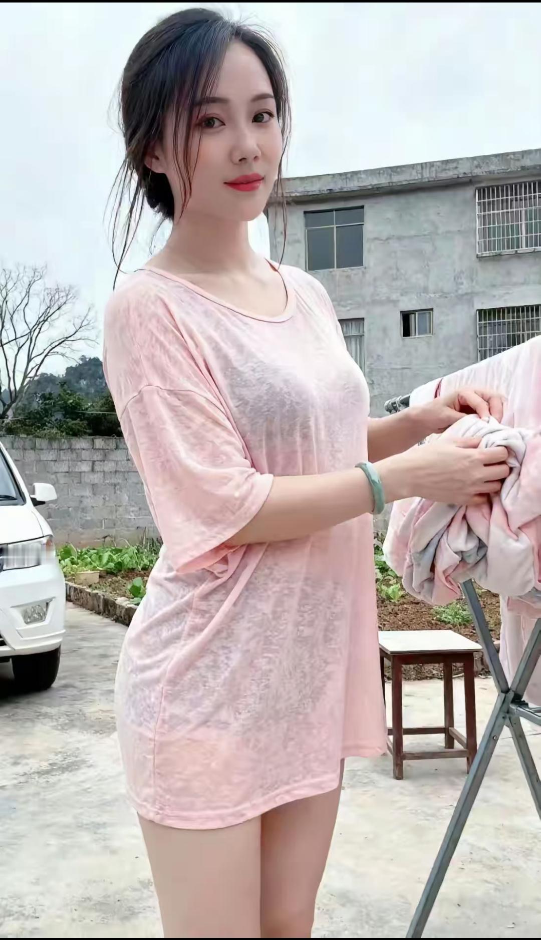 粉衣美人晾衣时，微风拂面笑语生。