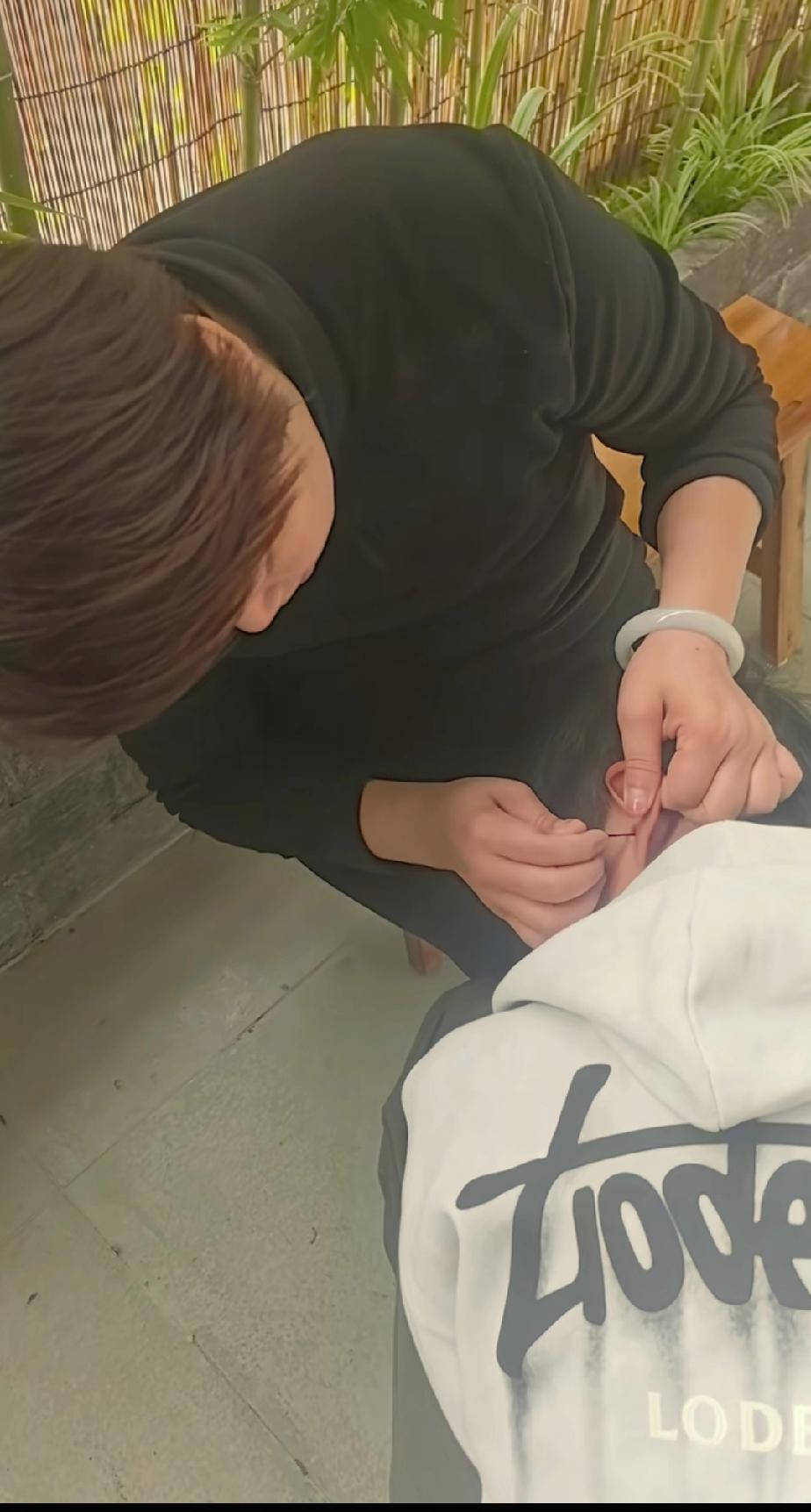 大喇叭叶锐聪妈妈正在帮叶锐聪掏耳朵。叶锐聪妈妈真把19岁的大男孩当成两三岁的娃娃