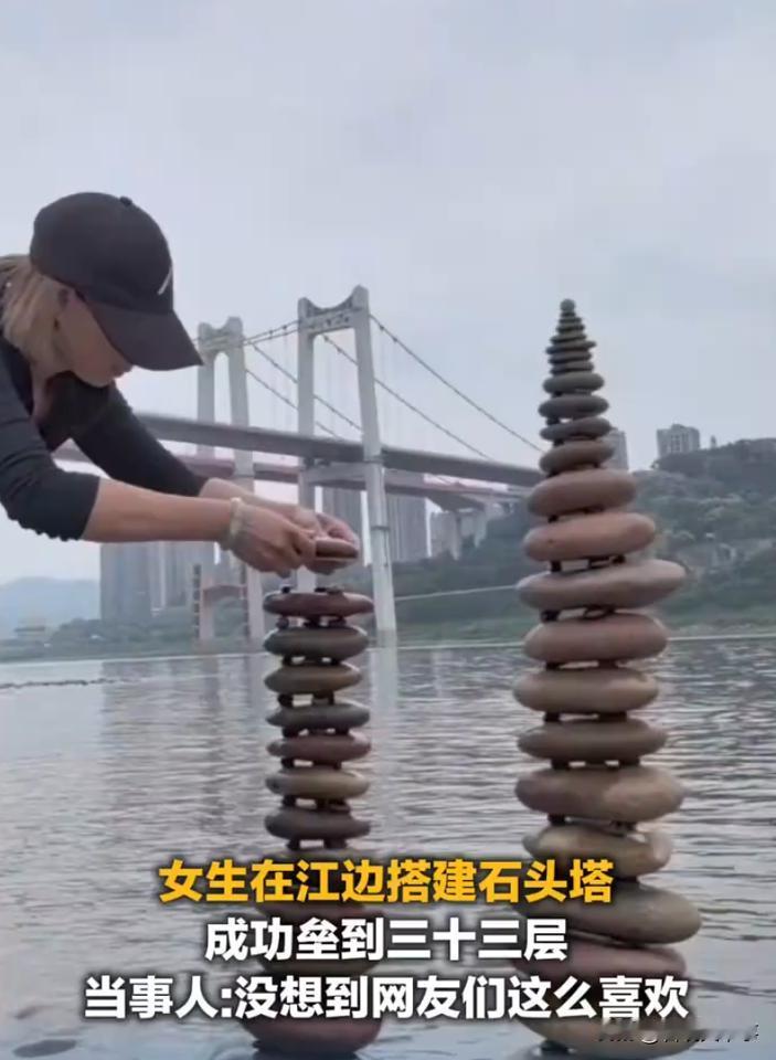 这艺术成分太高了！重庆，一女子去江边游玩，看到旁边有很多的石头，心血来潮就搭建起
