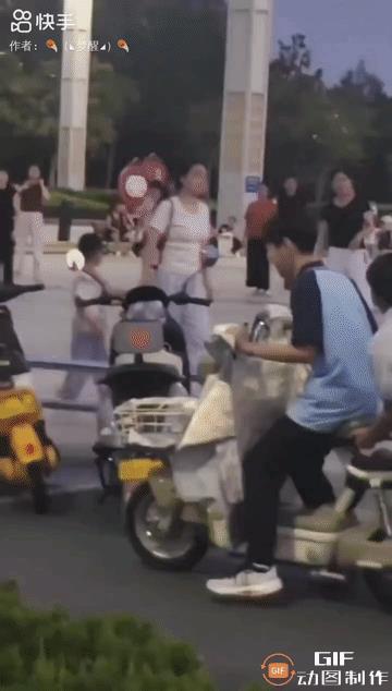 一群大妈正在尽情畅快地扭动着腰身，疯狂地跳着广场舞。突然，两名少年悄悄地来到音响