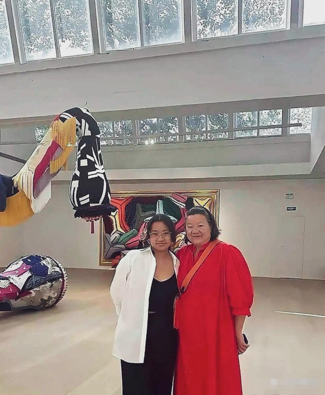 陈凯歌前妻洪晃与女儿的合影！妈妈身宽体胖，身穿一件大红长裙。女儿白衣黑裙穿搭简单