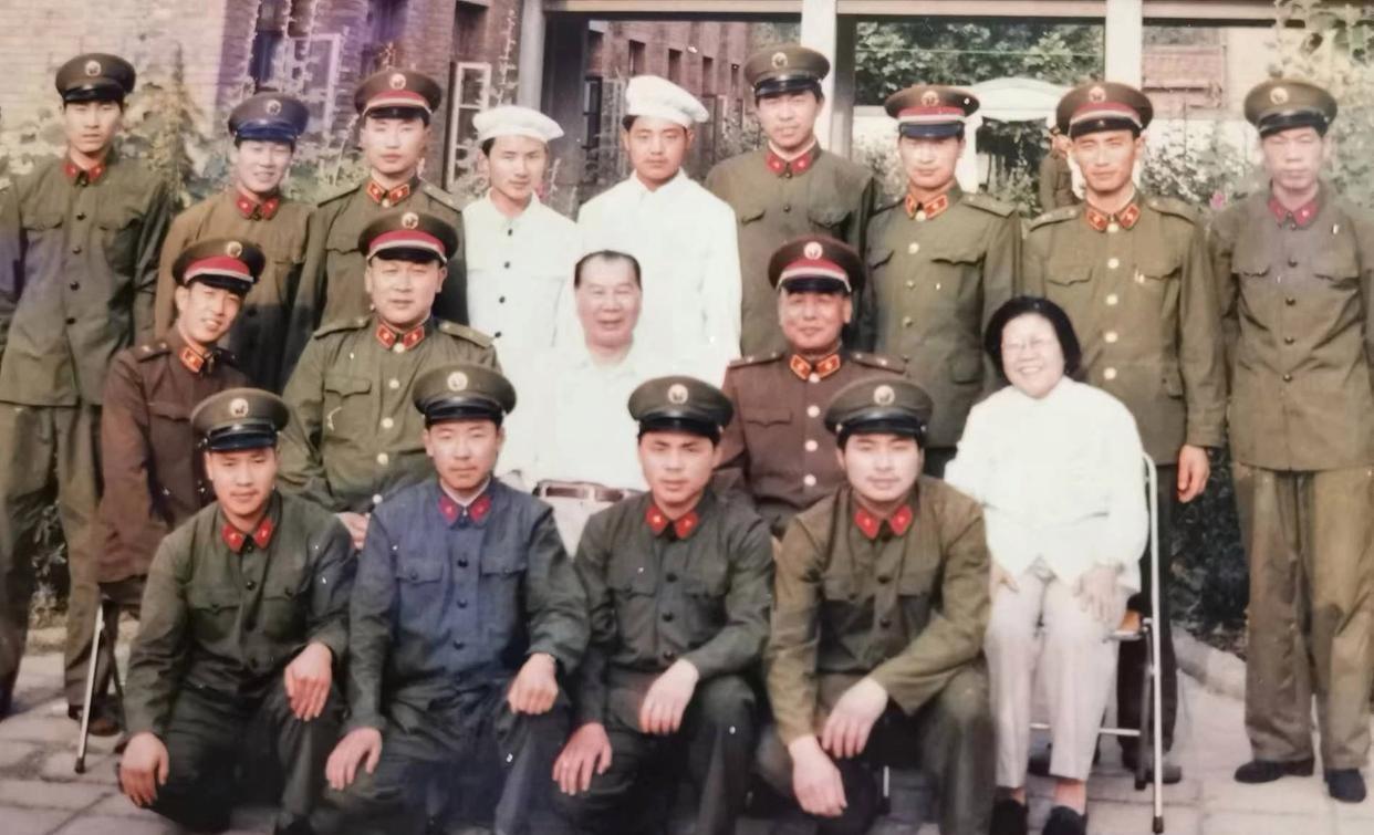 时任20集团军军长的梁光烈站在中排，身姿挺拔，眼神坚定，彰显着军人的英气。中排左