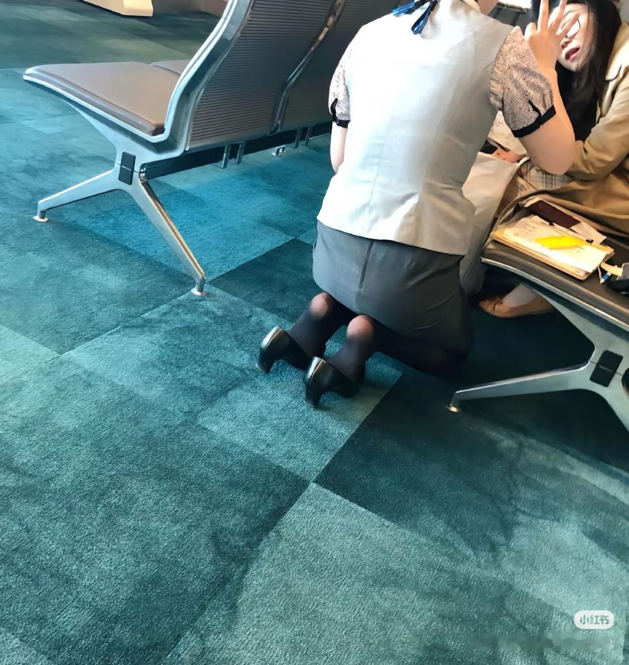 刷到机场这一幕，我心里说不出的滋味。穿着制服的工作人员，就这么跪在冰冷的地板上