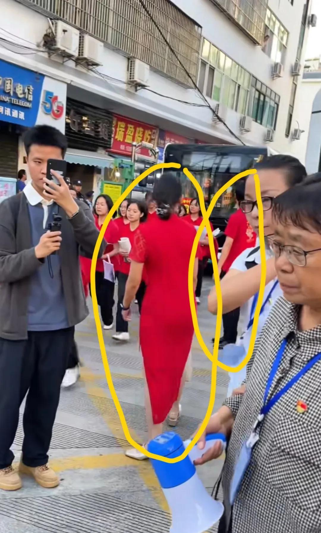 张桂梅送考，大巴车旁有两个人，一男一女在管理，这个不知道是不是华坪女高老师。女