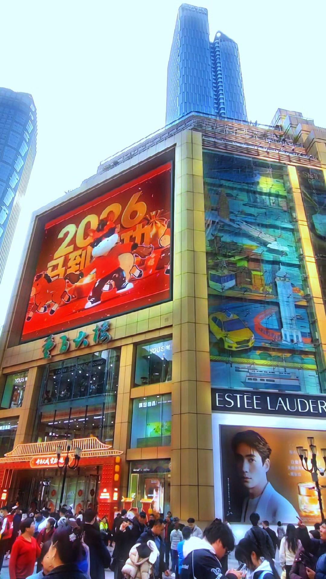 在重庆，解放碑旁高楼群构成繁华CBD。蓝天中玻璃幕墙映着“8D魔幻”面孔，是金融