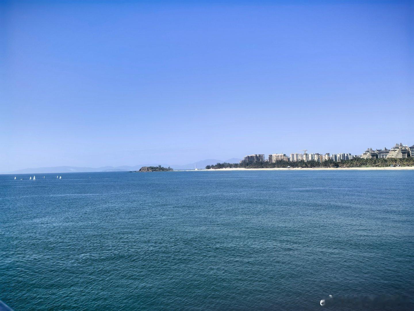 阳光、沙滩、海浪，天气真好，海上很多人在玩帆船，灯塔就是电影消失的她里面那个灯塔