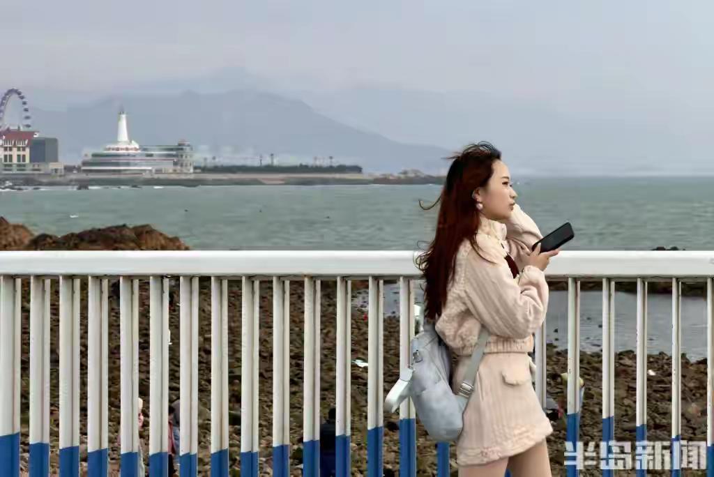 青岛小麦岛惊现治愈系风景线！游客顶17℃海风漫步海岸线，摄影师拍下震撼画面初