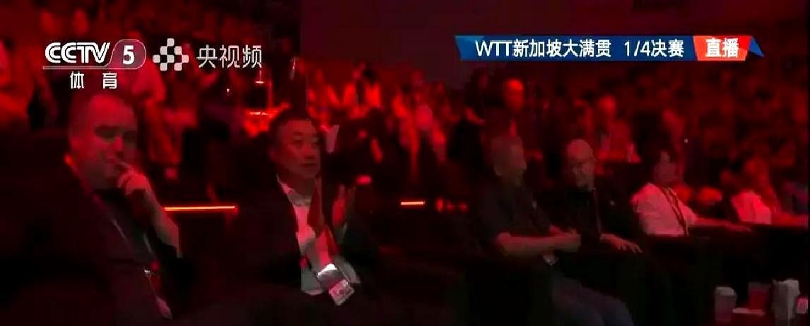 刘国梁坐普通观众席，手肘压着塑料椅扶手，眼睛死盯孙颖莎发球——国际乒联第一副主席