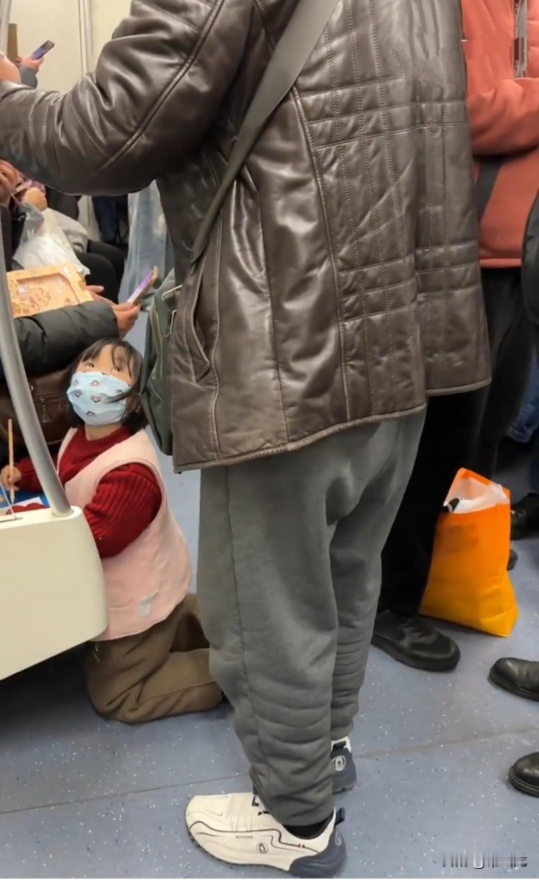 女孩趴在地铁座位上写字，站在旁边的老头不乐意了：“这是坐的，不是玩的，懂不懂。”