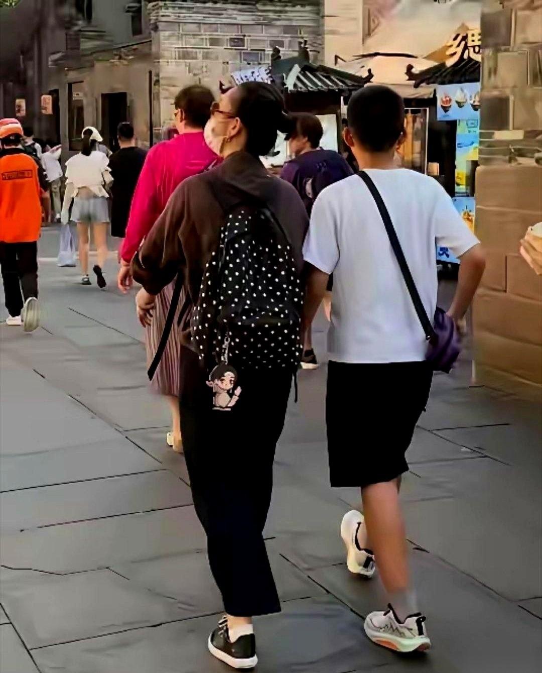 王新军拉着行李箱，秦海璐就跟在旁边，11岁的儿子个头猛蹿，几乎快跟妈一样高。一