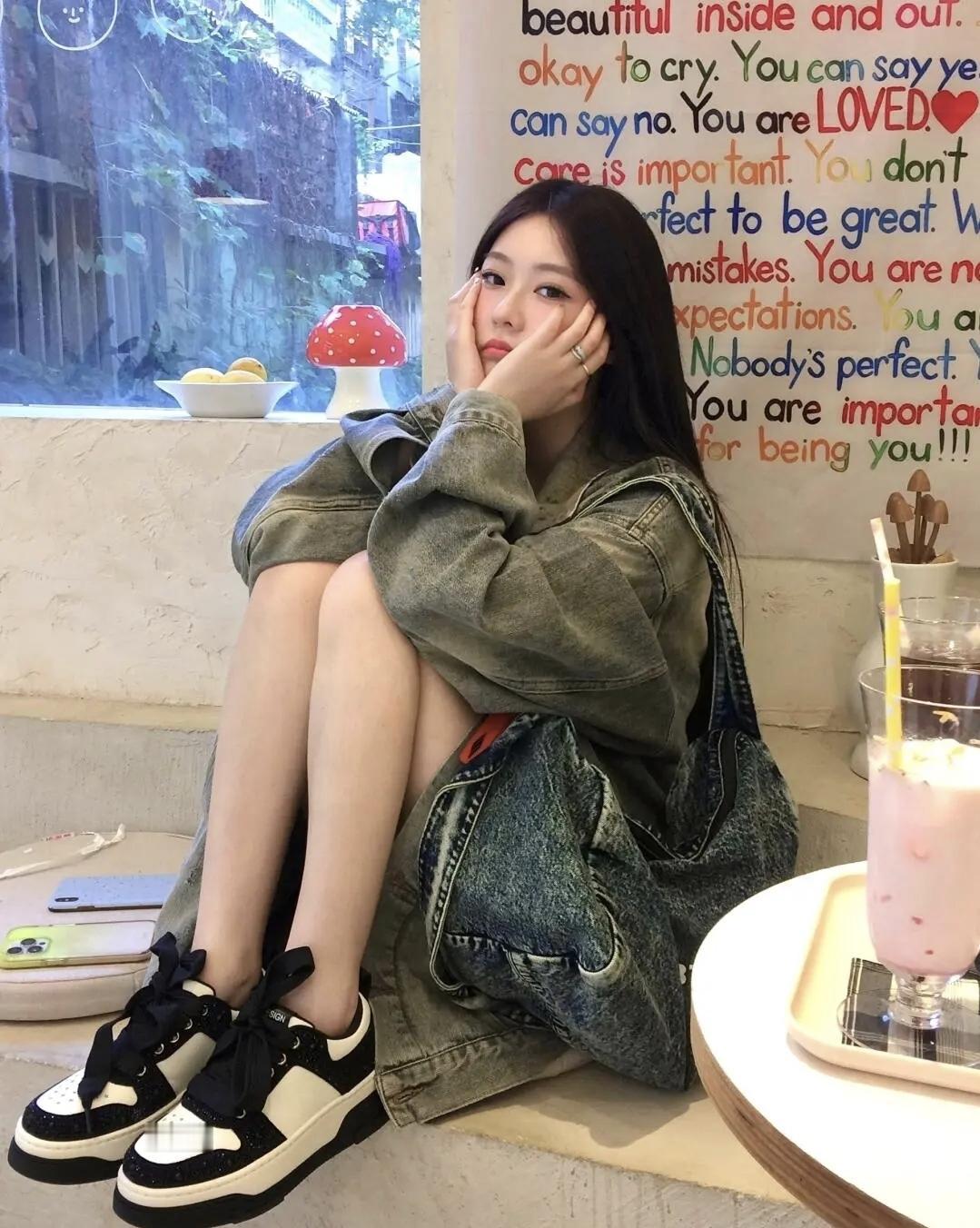 在满是治愈文字的小店角落，牛仔穿搭裹着慵懒的惬意，一杯粉色饮品甜化了午后时光，就