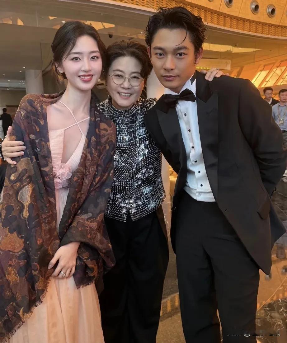 照片中站在中间的是大导演李少红，她气质优雅、沉稳大气、才识过人。那么，被她拥抱的