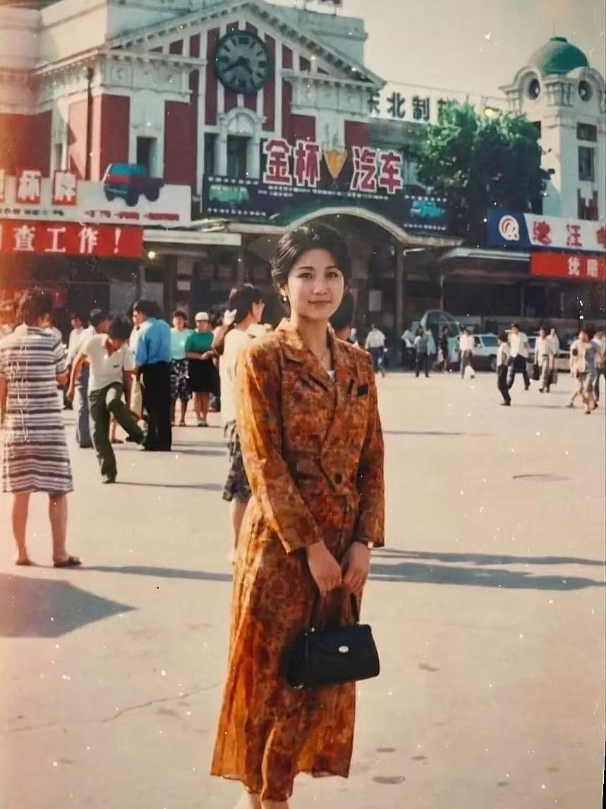 1992年，沈阳车站广场，一位30岁左右的美女刚下火车，在车站欧式主楼前留下了难