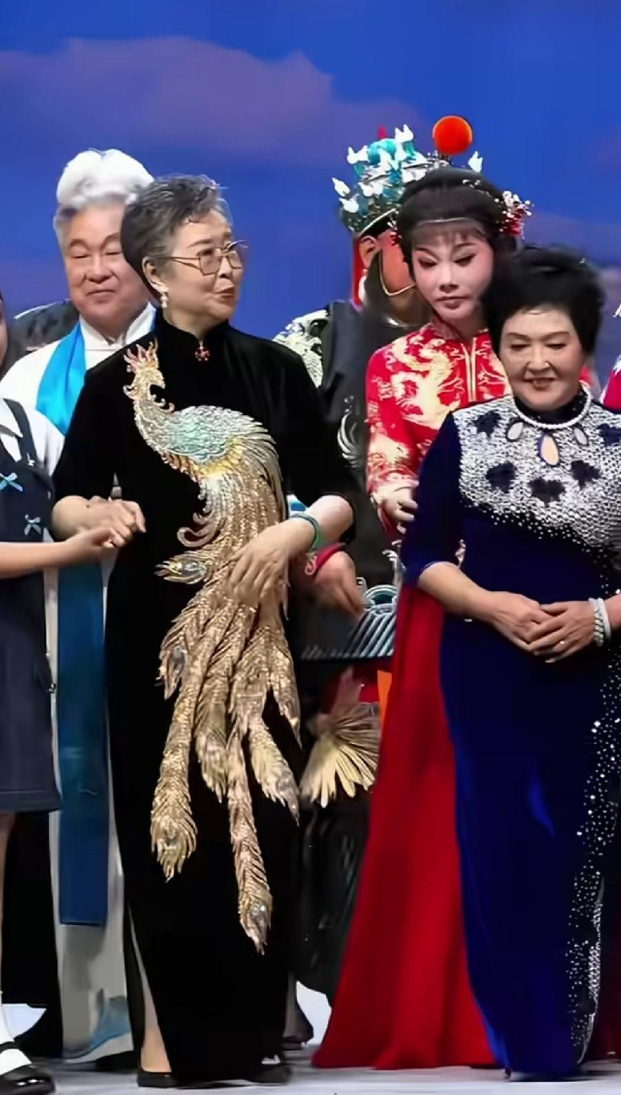 这事不是插队，是冲着镜头去的。她怀里那只大尾鸡尾巴翘着，翅膀还扑棱两下，主持人话