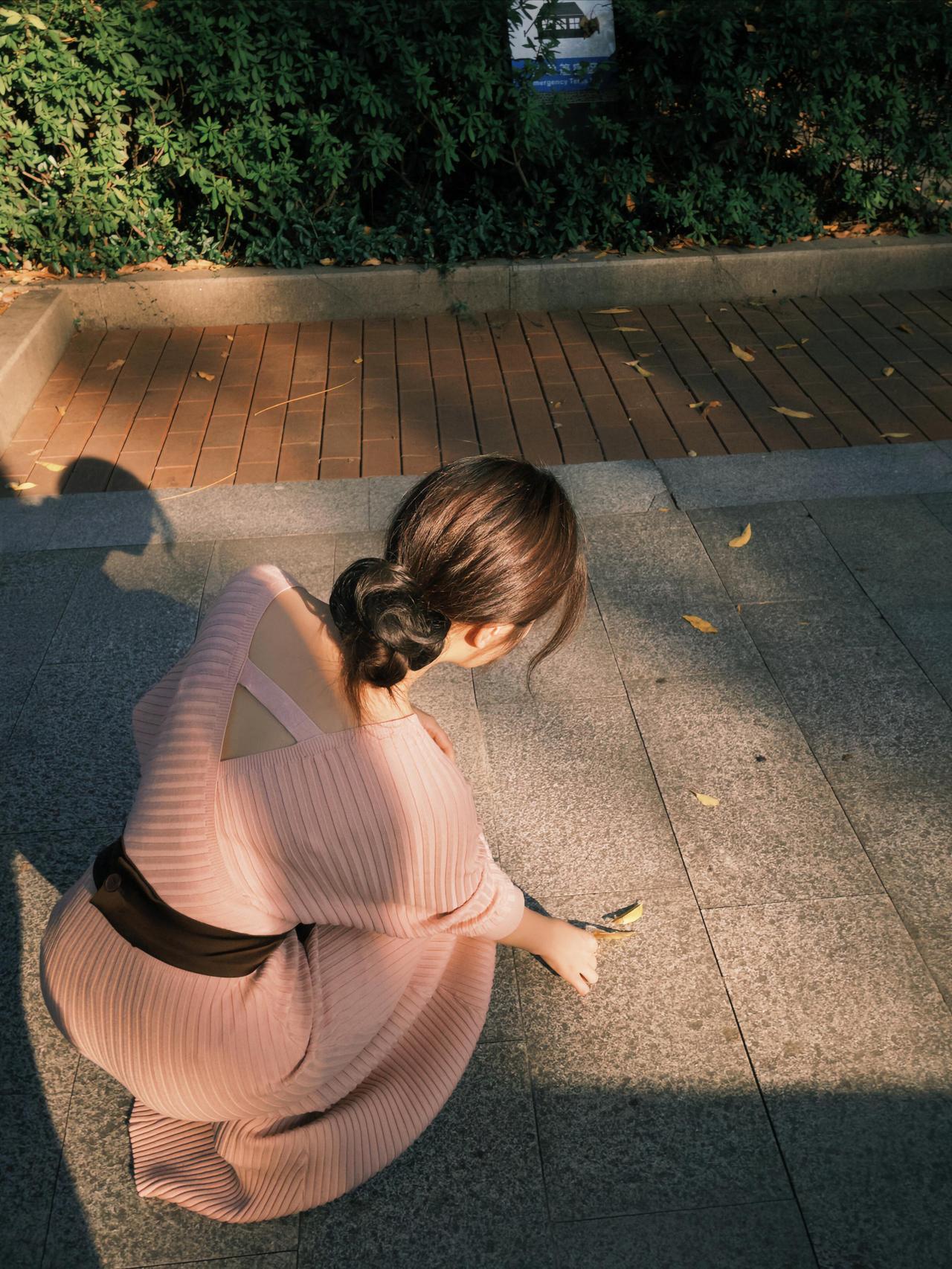 暮光漫过林梢，粉裙漾起温柔的褶皱。她立在树影斑驳的小径，像一株含羞的合欢，