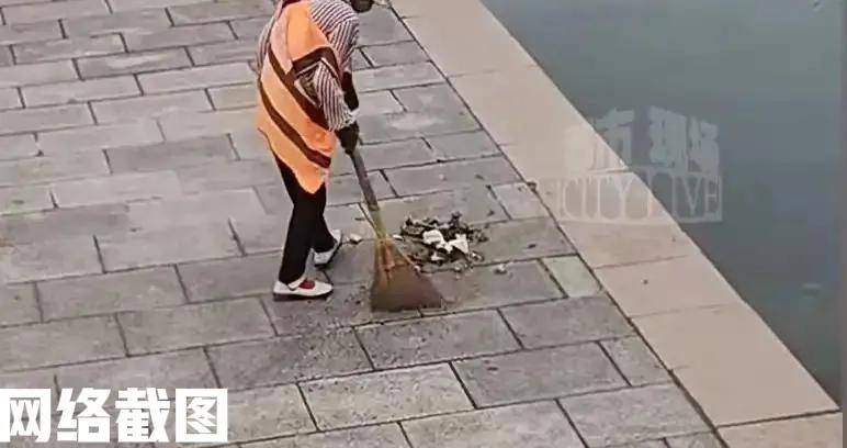 山东青岛有一景区做清洁的大妈。只见大妈把一旁清扫出来的垃圾，没有清理到垃圾桶