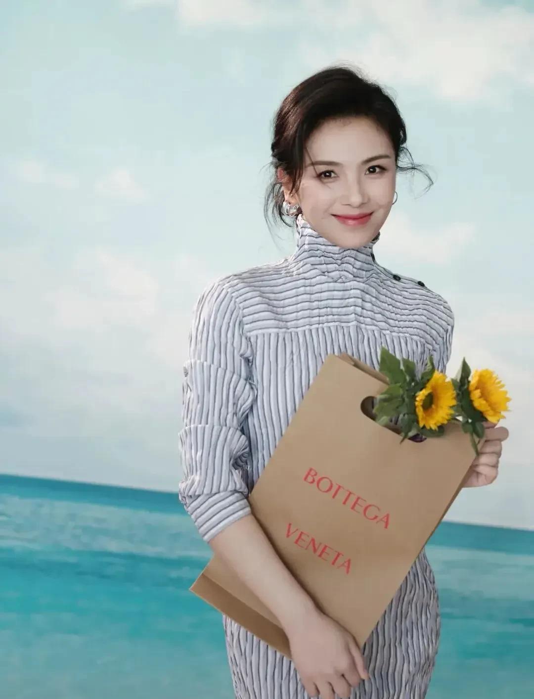 刘涛穿条纹裙，曲线藏都藏不住！手捧花、举椰汁，甜笑像把阳光攥手里，这状态直接把岁