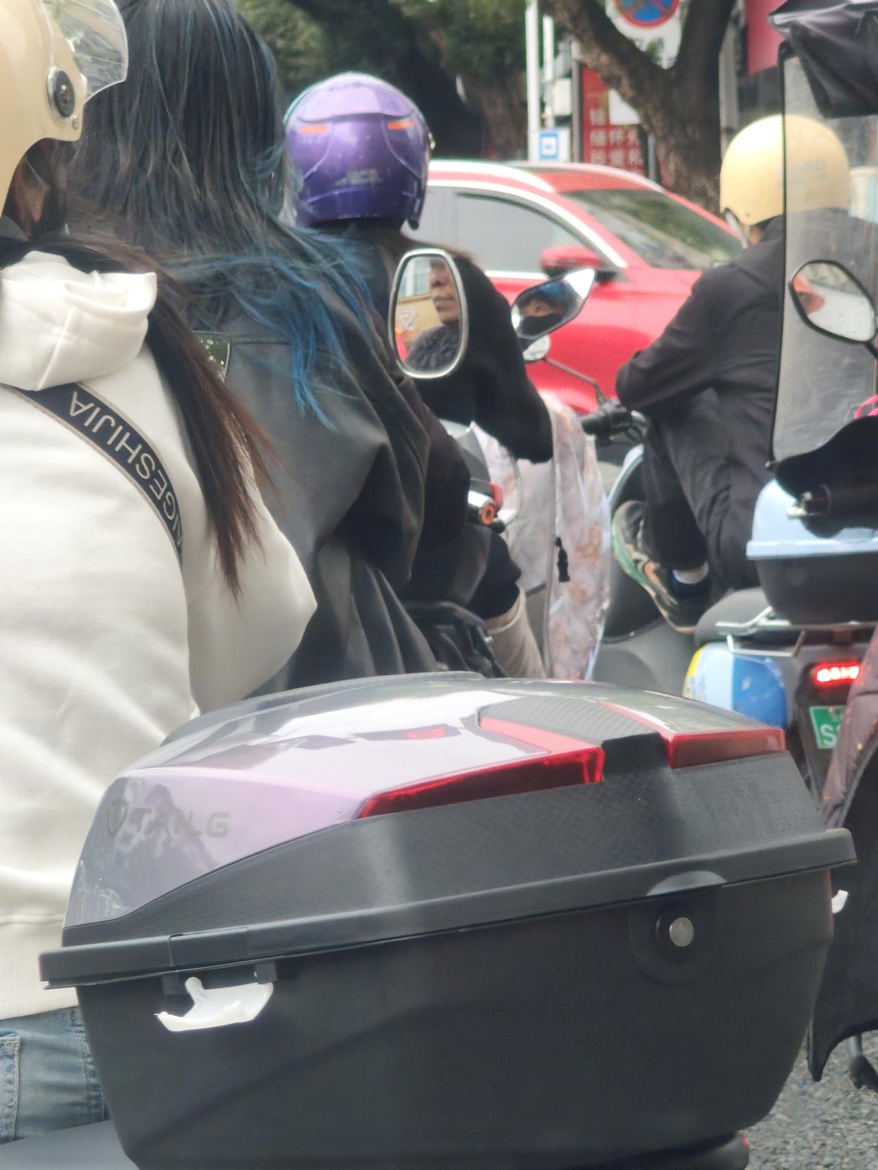 那个女孩的头发好特别。我开车遇到红灯，停了下来，看前面停着的摩托车。突然