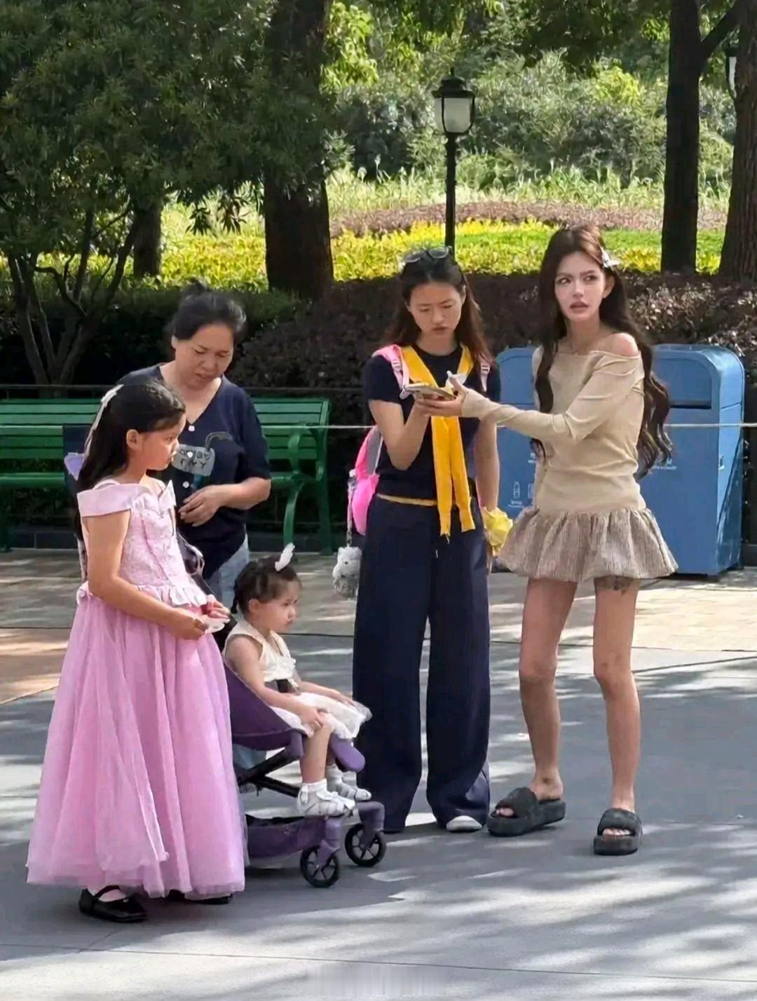 韩安冉带着两个女儿现身上海迪士尼游玩，她本人和精修图差好远啊，完全不是一个维度的！张柏芝抱着韩安冉的