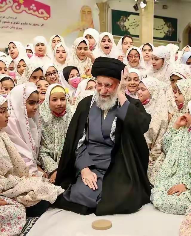 哈梅内伊坐在女人中间，哈梅内伊走在军队前面。前者好像身处花丛中，后者好似经过树林