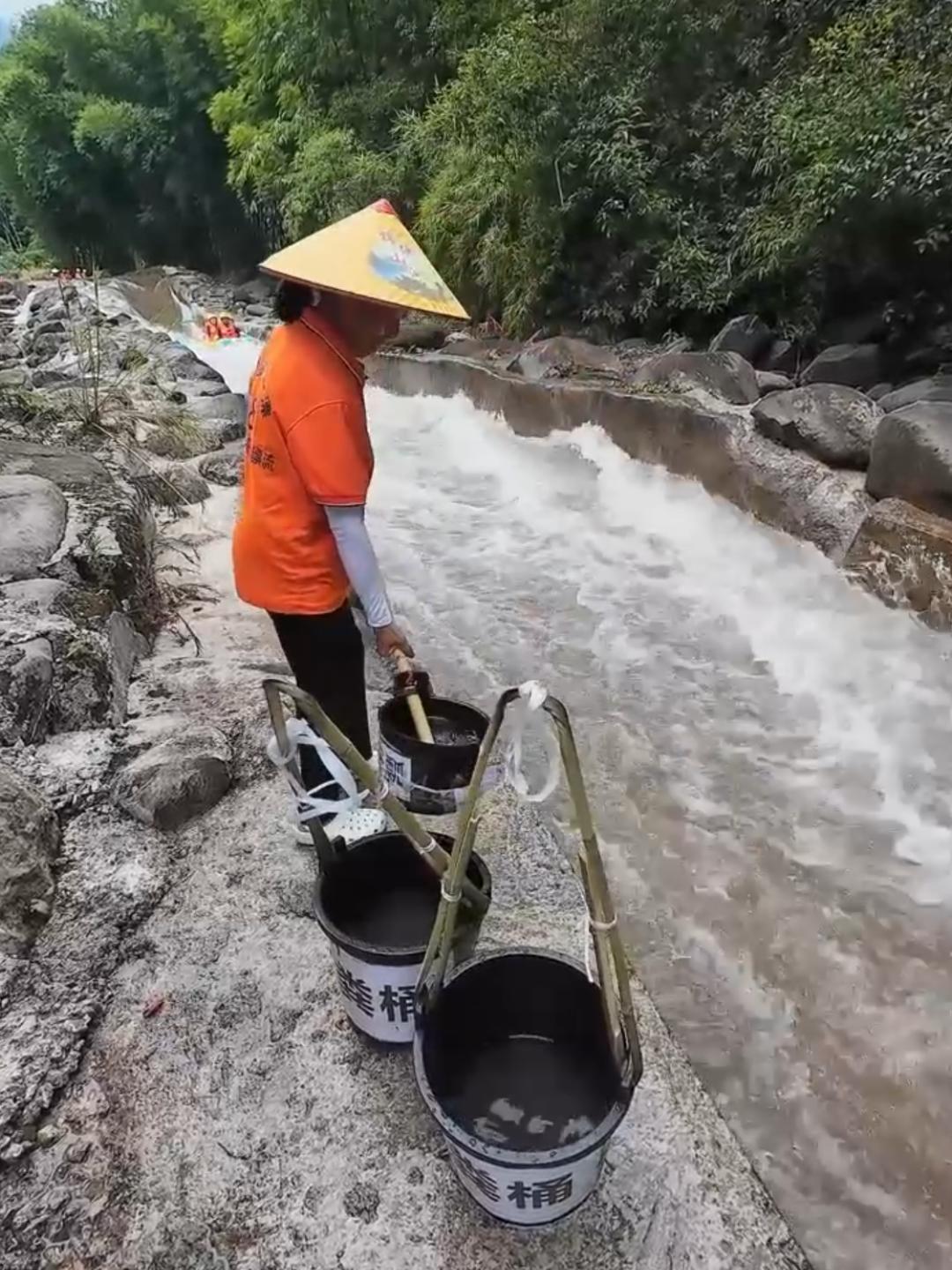 四川一漂流景区，有一段河道，景区专门安排了泼水互动，一位泼水员阿姨在漂流河