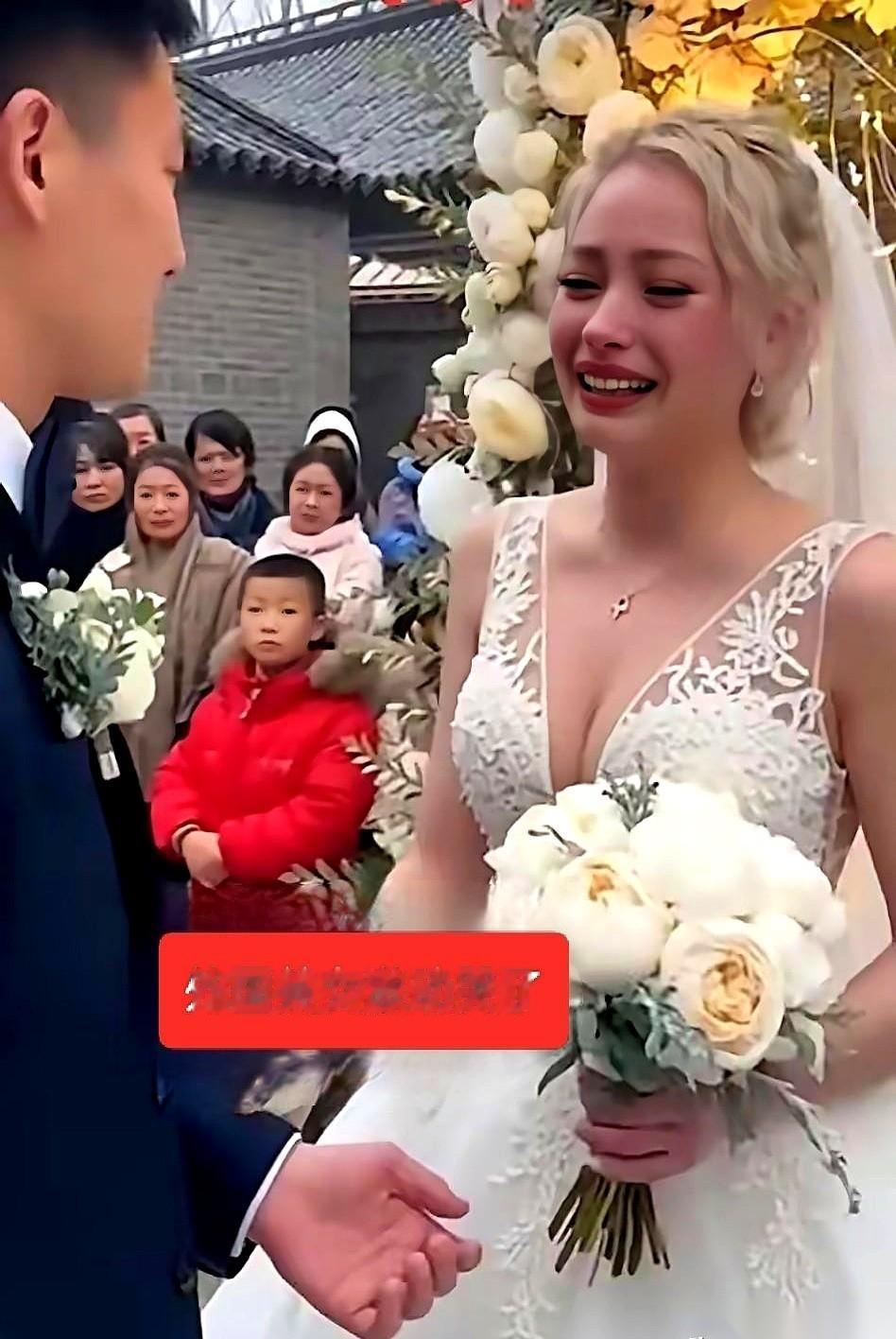 一个外国姑娘，在自己的婚礼上，哭得稀里哗啦。旁边她老公，一个中国小伙，有点手足