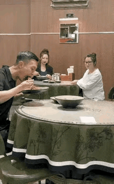 一男子在饭店吃饭，点了一碗面，同时吃饭的还有两位美女在另一桌吃饭。只见男子一