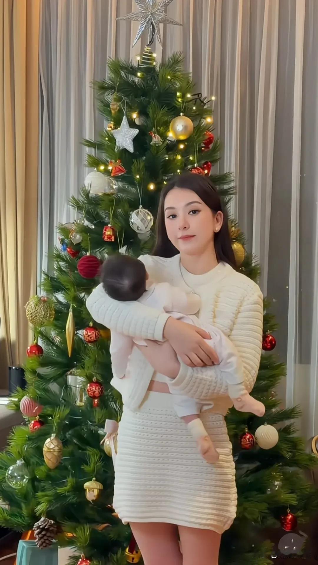 天王嫂方媛抱着三宝，在家里的圣诞树前合照。看画面，三宝发量好多啊，头发乌黑浓密