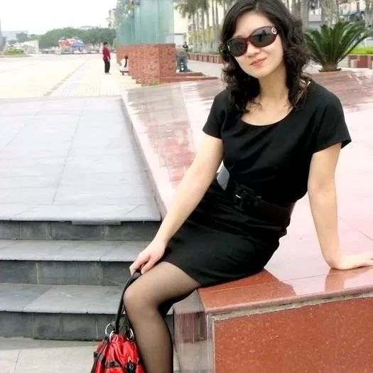 都市时尚女郎，黑色连衣裙，自信笑容，街拍瞬间。