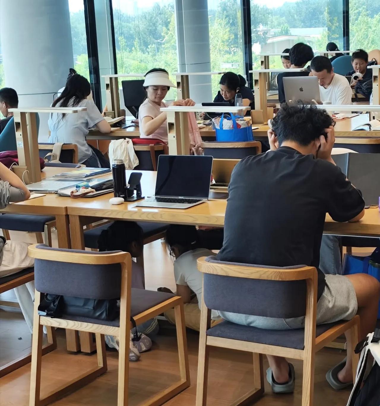 北京城市图书馆，大家都在安静的看书，这两个小朋友在干嘛？