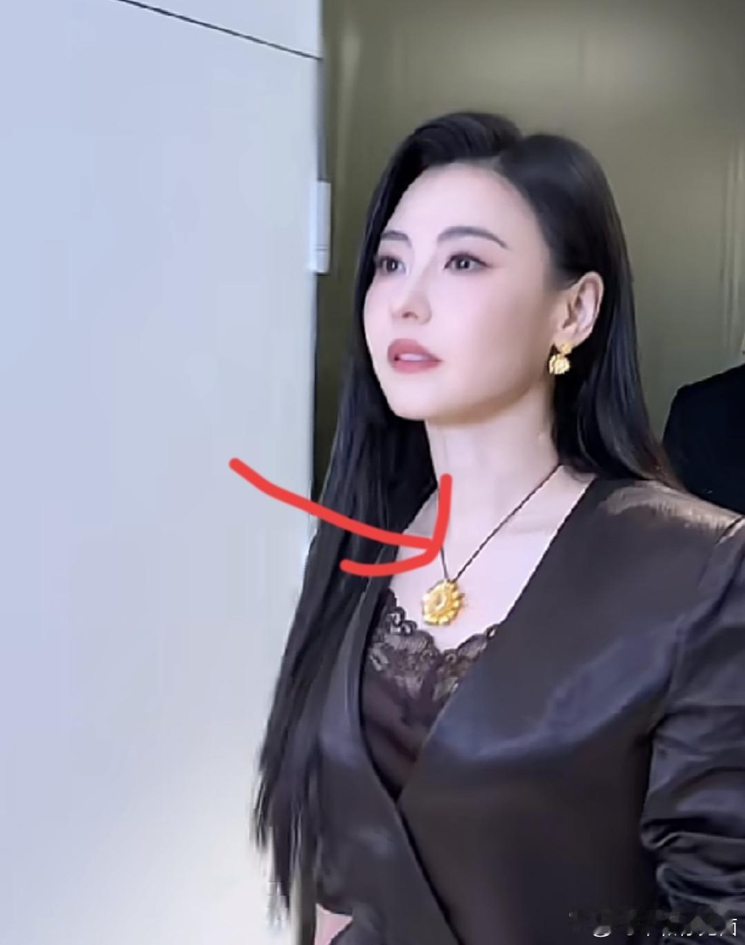 一身黑西装，脖子上挂一朵金灿灿的大太阳花，张柏芝这是要把黄金戴出钻石的架势啊！