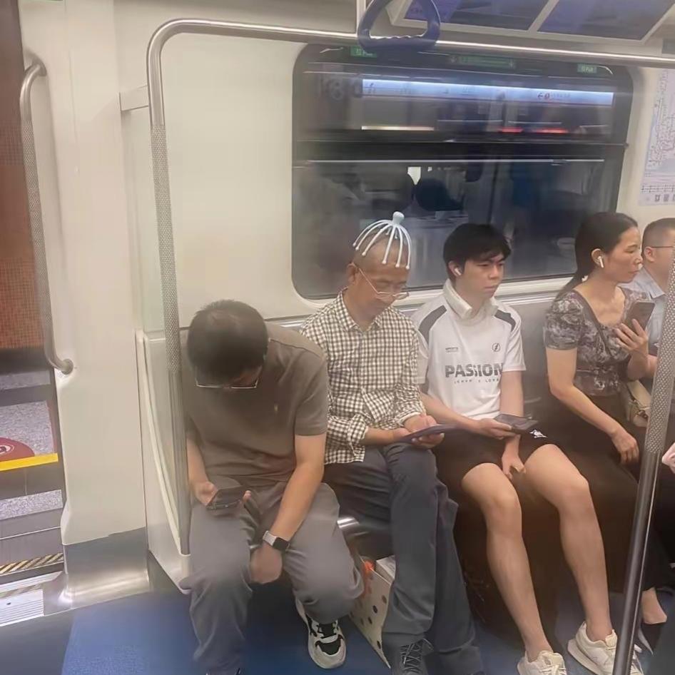 地铁偶遇一幕，当场把我笑喷！一位大爷戴着头部按摩神器安安稳稳坐着。周围不少